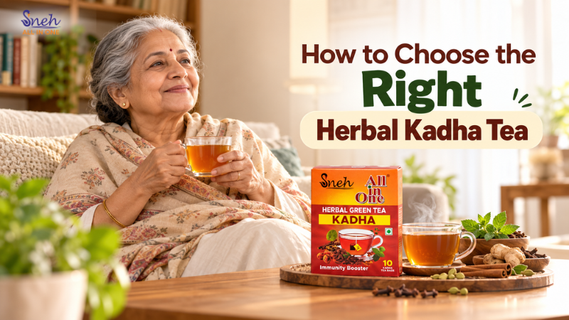 Smiling elderly woman holding a cup of herbal kadha tea beside a Sneh All in One Herbal Green Tea Kadha box and spices.